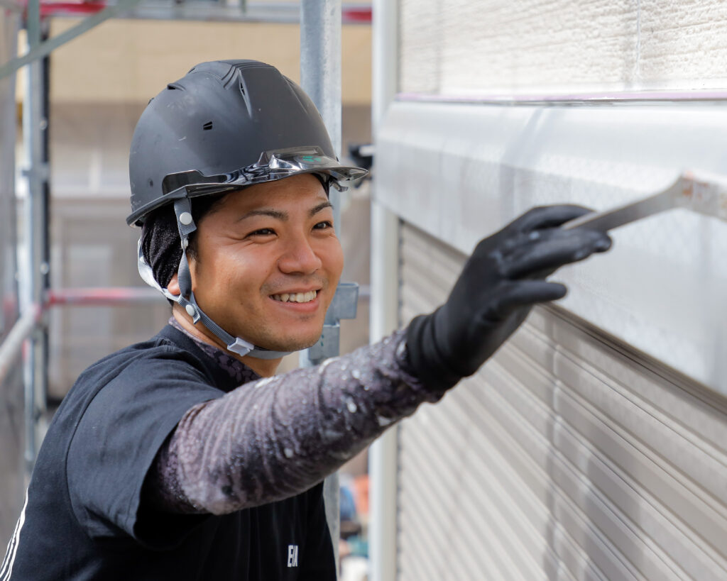 笑顔で作業する、縁家の塗装職人