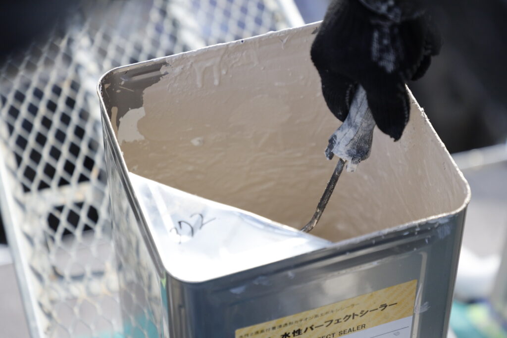 外壁塗装に使う塗料をかき混ぜている写真